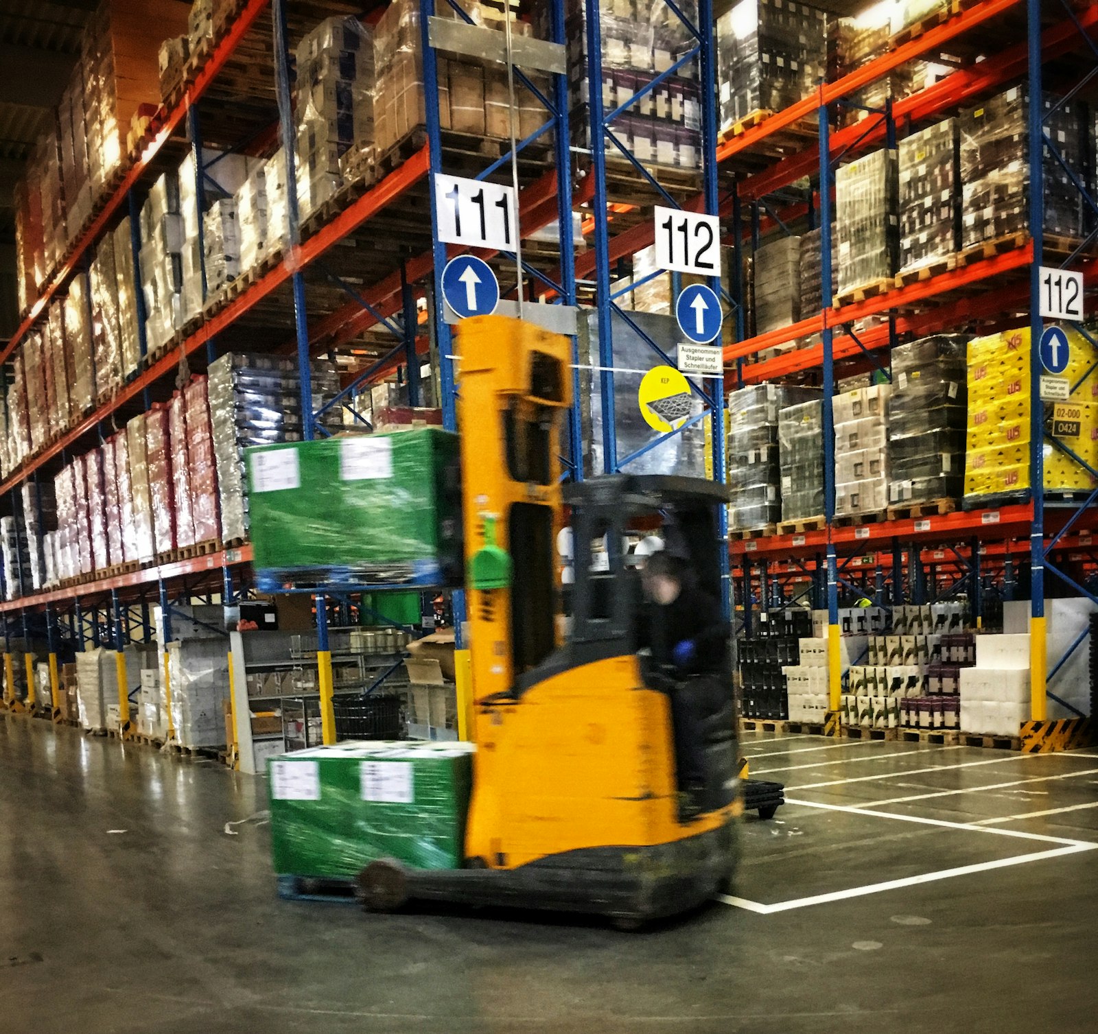 Forklift moving pallets inside an industrial warehouse